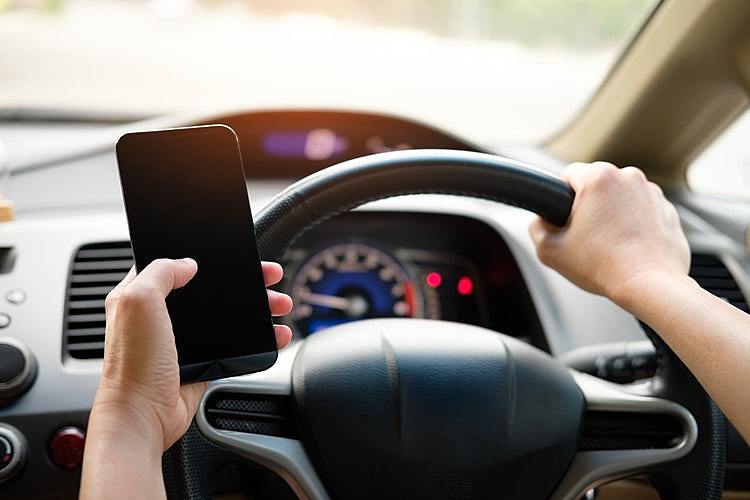Person Holding Black Smartphone And Vehicle Steering Wheel 1028742